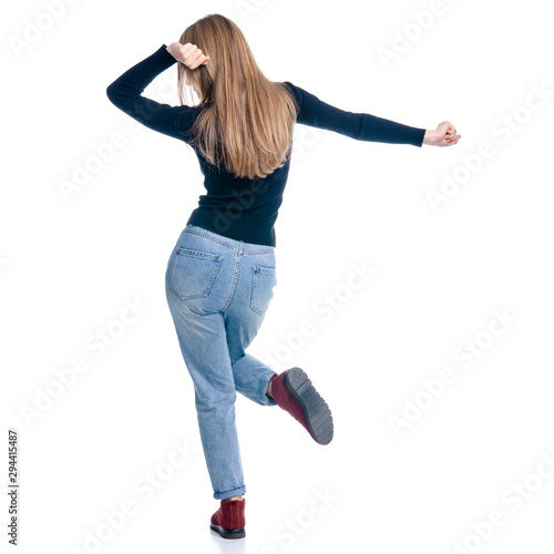 Woman in jeans and sweater happiness dancing smiling on white background isolation, rear view