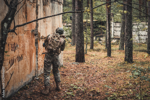Airsoft player checking the hole in the wall
