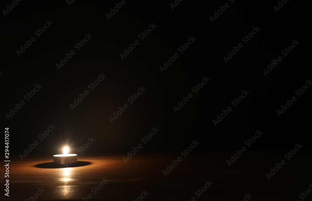 Burning candle over black background Stock Photo | Adobe Stock