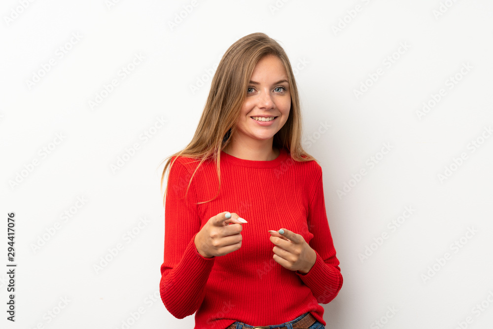 Young blonde woman with red sweater over isolated white background points finger at you Young blonde woman with red sweater over isolated white background points finger at you