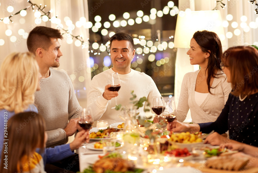 celebration, holidays and people concept - happy family having dinner party, drinking red wine and toasting at home celebration, holidays and people concept - happy family having dinner party, drinking red wine and toasting at home
