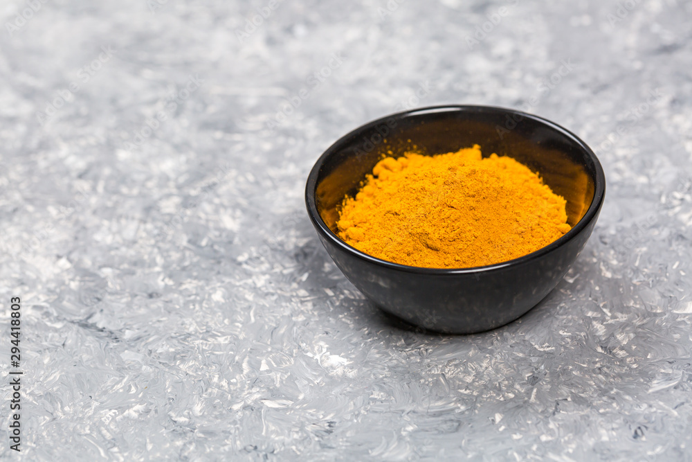 Fototapeta premium Turmeric powder close up on a grunge cooking table