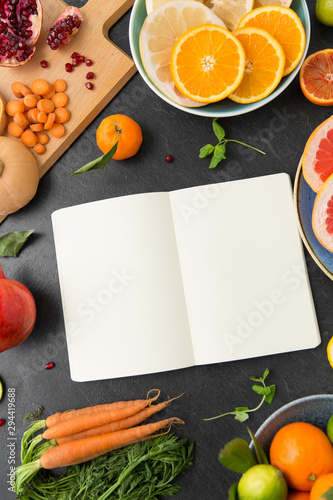 food  healthy eating and diet concept - close up of notebook  fruits and vegetables on slate table top