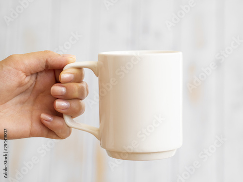 Close-up hand holding up a mug