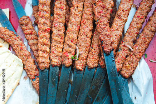 Traditional Turkish Adana Kebab or Kebap on the grill with skewers in the turkish restaurant for dinner. Turkish cuisine food culture in Turkey.