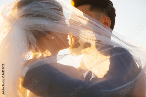 Bride and goom almost is kissing - close up image in the sunset light. photo