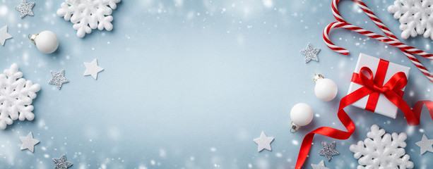 Christmas background with snow effect. Gift or present box, white snowflakes and holiday decoration top view. Happy New Year card.