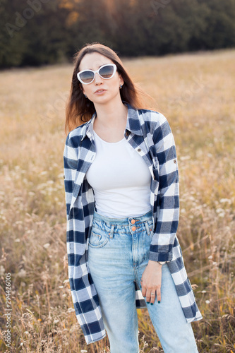 Young woman in sunglasses walking on the autumn field. © Dima Aslanian