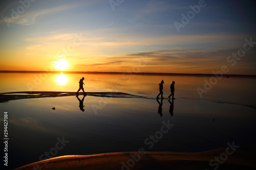 Beautiful sunset with silhouettes of children and reflection in lake