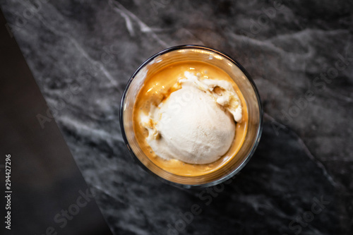 Affogato coffee: espresso shot with salted caramel icecream on classic marble table background, top view. photo