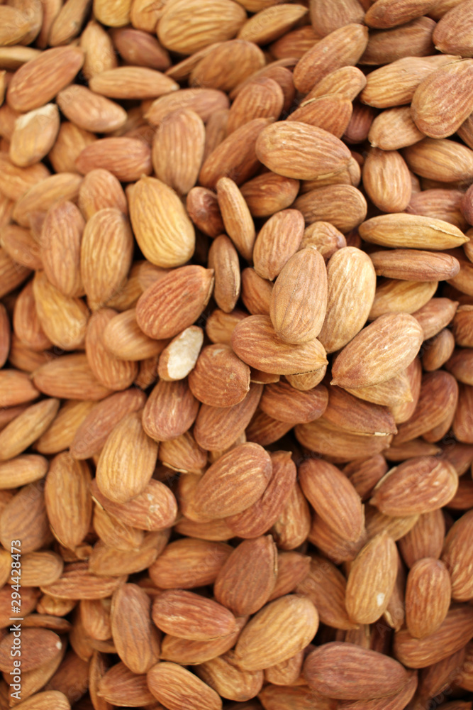 Almonds. Overhead view of raw organic almonds as a background. Peeled almond nuts. Healthy food concept. Vegetarian. Nuts pattern Almonds. Overhead view of raw organic almonds as a background. Peeled almond nuts. Healthy food concept. Vegetarian. Nuts pattern