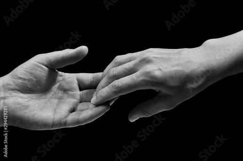 Obraz na plátně Black and white photo of two hands at the moment of breakup