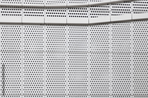 building with steel sheet pegboard or orderly holes wall.
