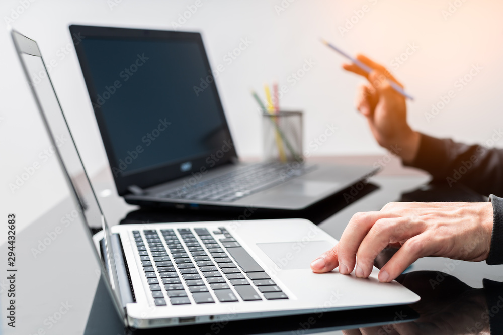 male graphic designer working on laptop computer with color pencils male graphic designer working on laptop computer with color pencils