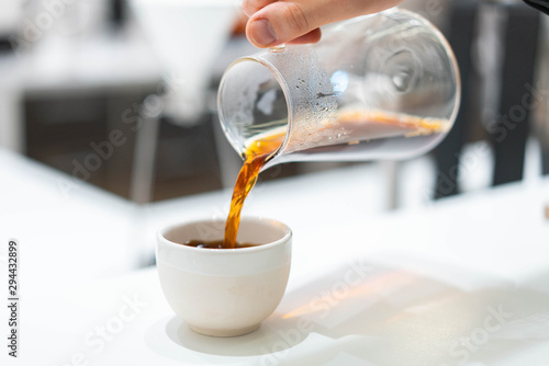 process of preparation black coffee in chemex pour over coffee maker in bright modern cafe. Alternative ways of brewing coffee.
