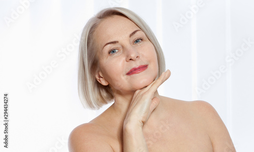 Beautiful middle-aged blonde woman shows off her perfectly well-groomed face. Plastic surgery collagen injections. Macro face. Selective focus on face. Realistic images with their own imperfections.