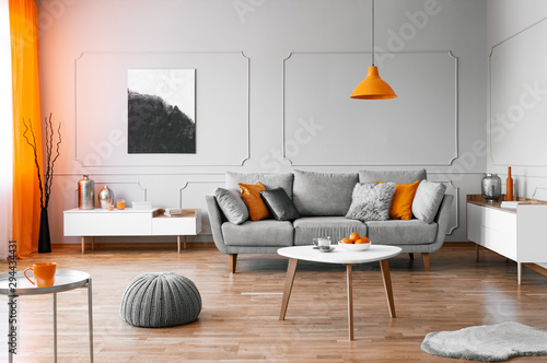 Stylish coffee table with kinck knacks in front of elegant couch with pillows photo