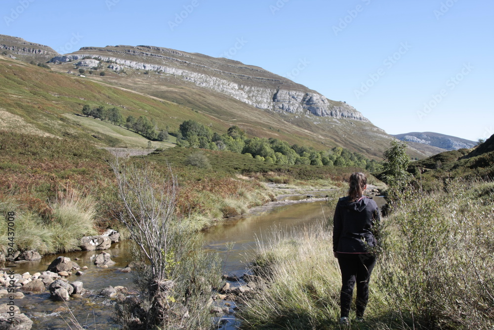 Mujer joven observando la grandiosidad del valle