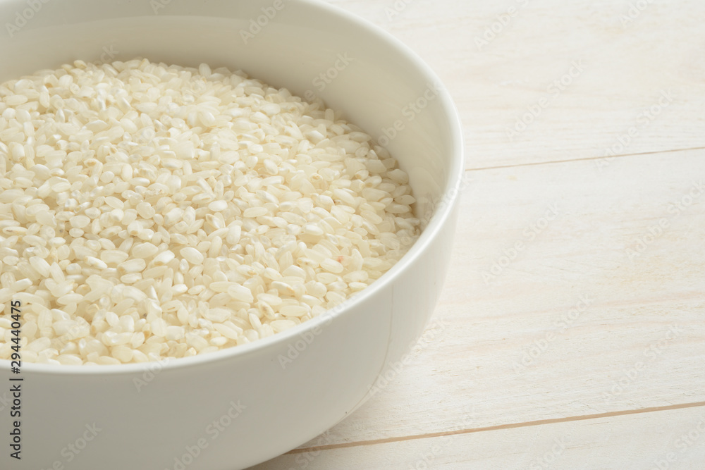 Arroz redondo blanco en un cuenco de cerámica blanca sobre la mesa blanca Arroz redondo blanco en un cuenco de cerámica blanca sobre la mesa blanca