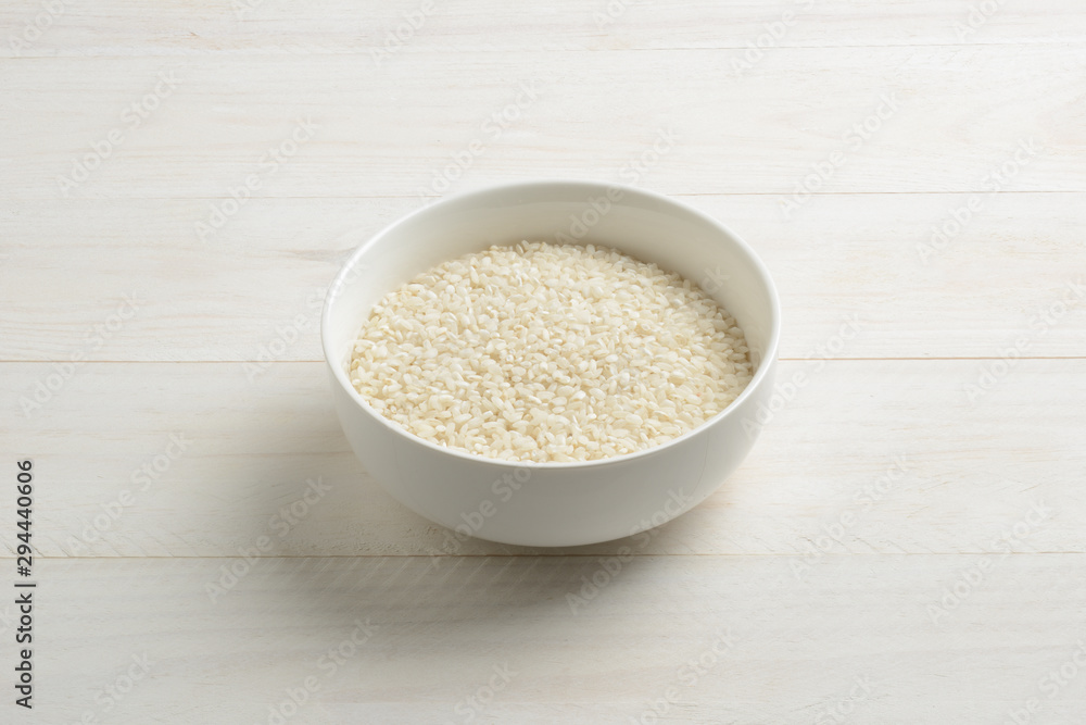 Arroz redondo blanco en un cuenco de cerámica blanca sobre la mesa blanca Arroz redondo blanco en un cuenco de cerámica blanca sobre la mesa blanca