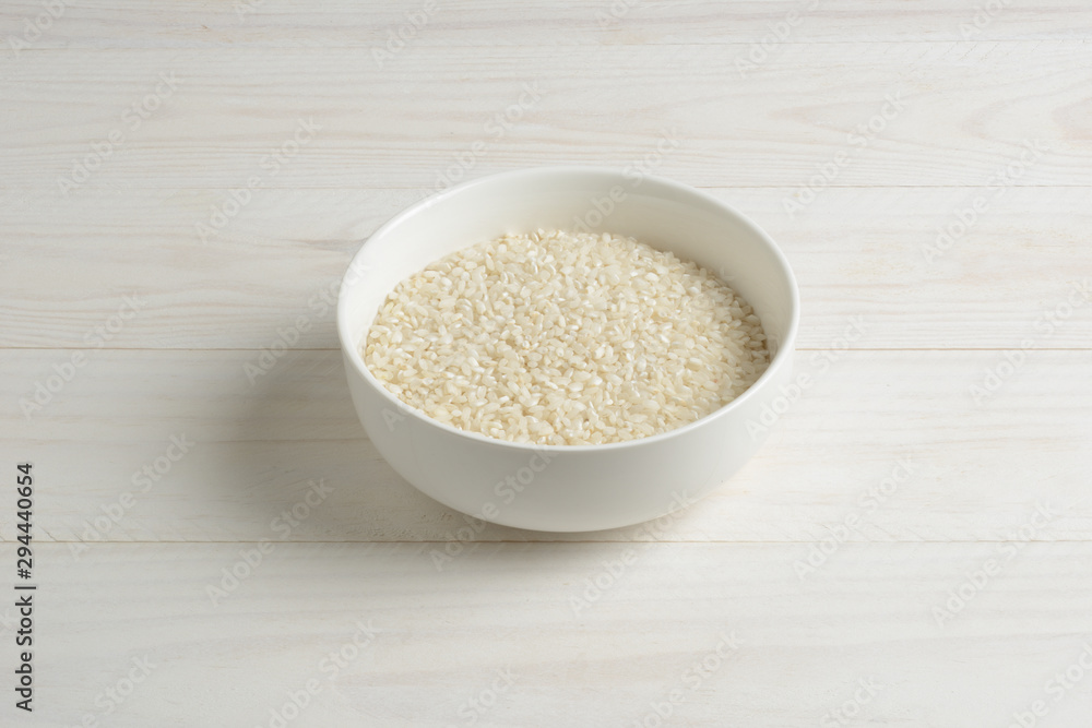 Arroz redondo blanco en un cuenco de cerámica blanca sobre la mesa blanca Arroz redondo blanco en un cuenco de cerámica blanca sobre la mesa blanca