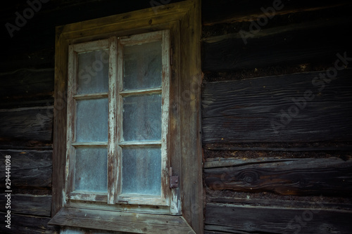 Old creepy scary window on wooden house. Halloween, haunted house concept.