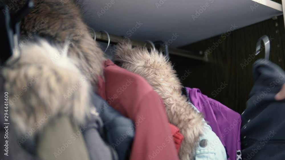 Girl putting her clother on hangers in the closet Girl putting her clother on hangers in the closet