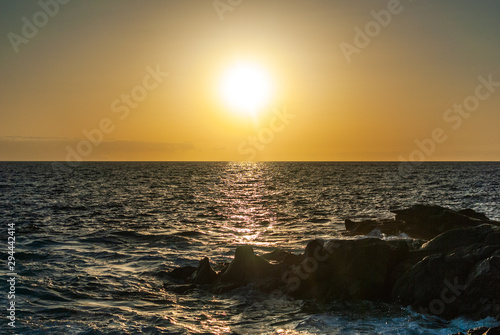 the sun sets over the horizon of the ocean