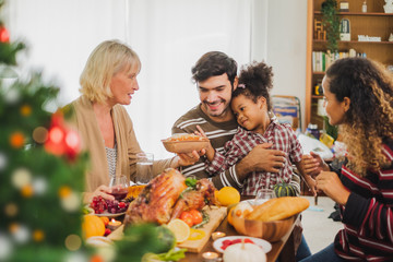 Happy Thanksgiving dinner party with family and food with turkey on table