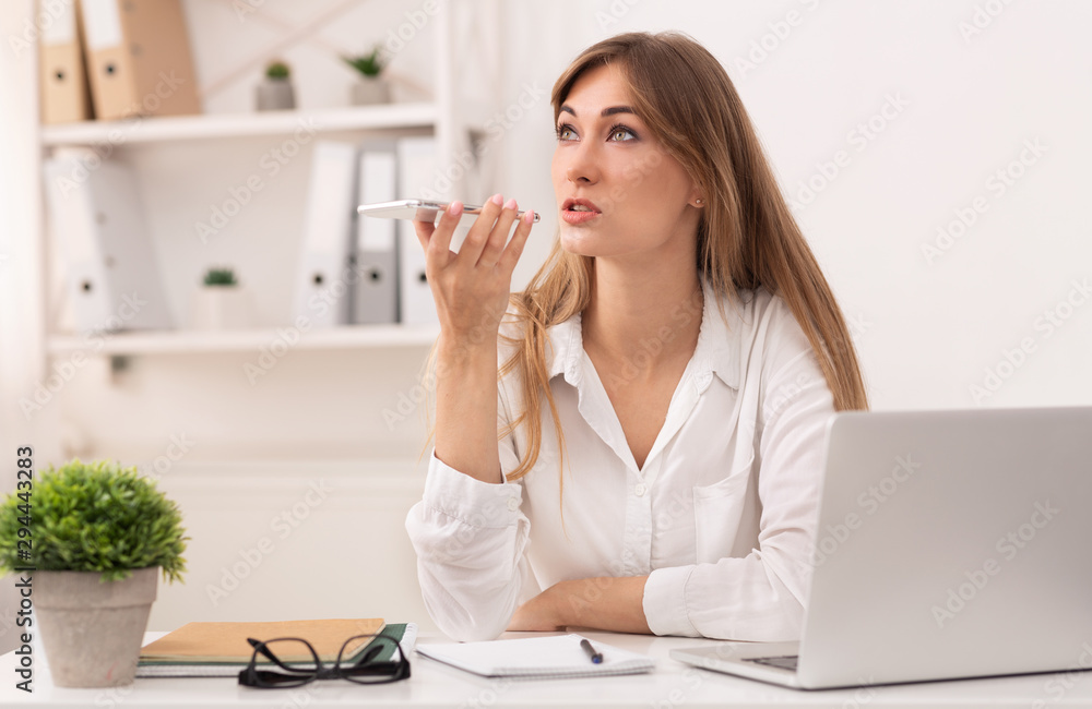 Businesswoman Using Cellphone Voice Assistant Working In Modern Office Businesswoman Using Cellphone Voice Assistant Working In Modern Office