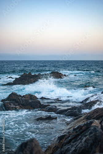 waves crash on stones canary islands, evening ocean