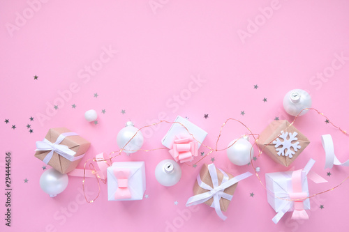 Christmas background with decorations and gift boxes on pink background