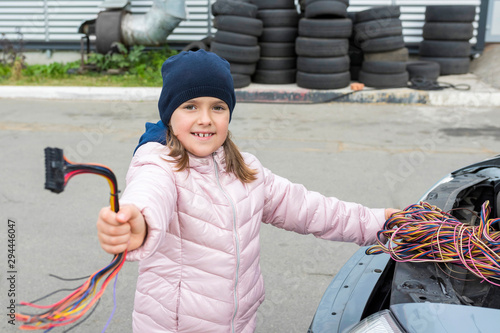  A child mechanic changes fuses in a car. Repair services in car service. photo