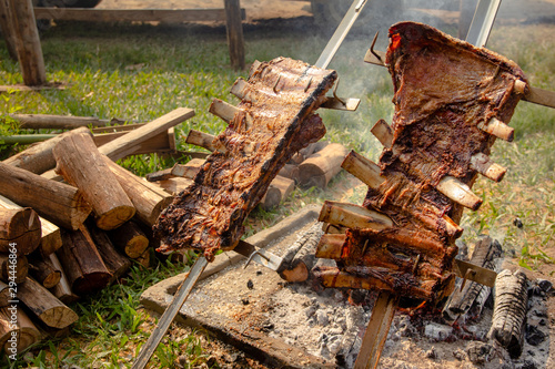 Two large pieces of beef rib. Typical BBQ campfire using skewers.