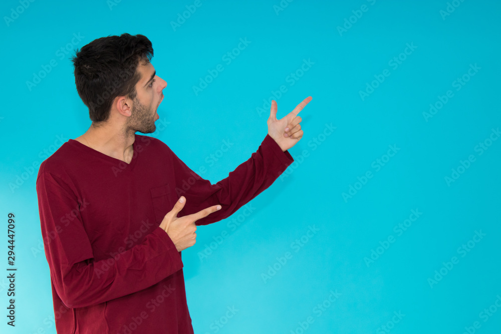isolated young man pointing at color background isolated young man pointing at color background