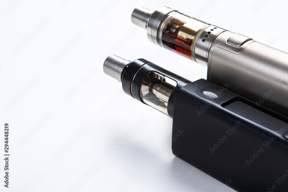 Vape. Vaping. Inventory for Vaper. Two electronic cigarettes are lying on  the table. Safe smoking. Fighting a bad habit. Reduce nicotine intake. vape  gadgets. Safe cigarette. Smoking e-cigarettes. Stock Photo | Adobe