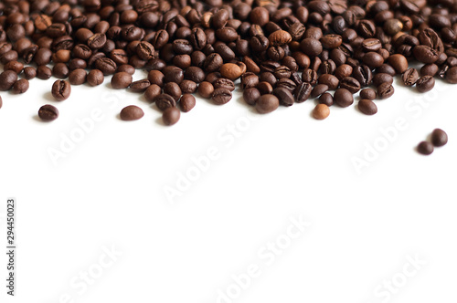 Freshly roasted coffee beans laid out on a white surface from top to bottom with a copy-paste place below.
