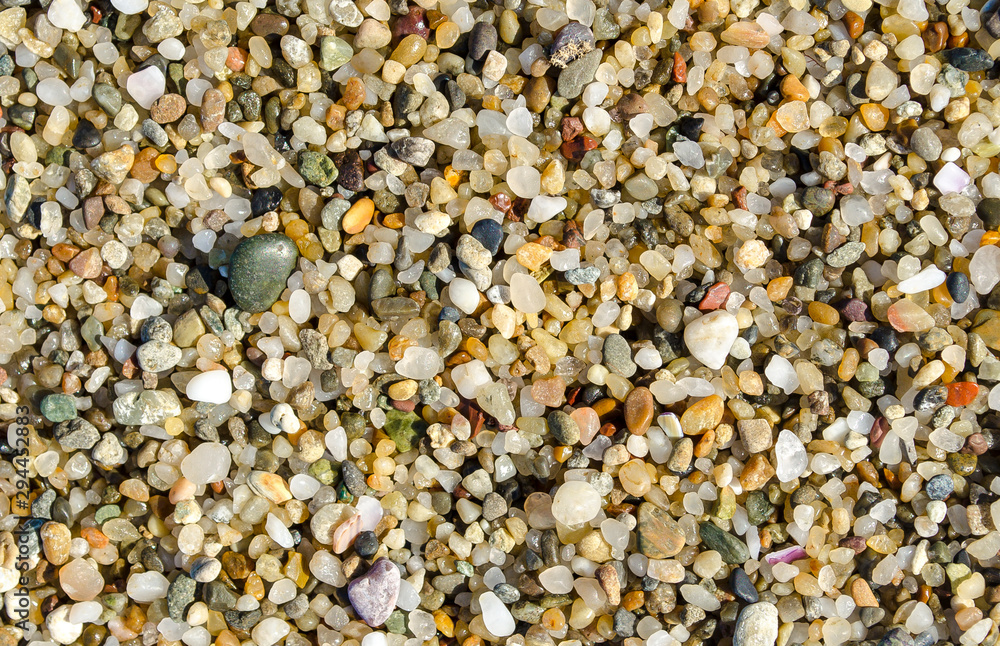 Pebble beach. Small colored sea stones close-up. Multicolor seabed. Selective focus image, copy space. Sea beach backdrop. Summer holiday concept. Pebble beach. Small colored sea stones close-up. Multicolor seabed. Selective focus image, copy space. Sea beach backdrop. Summer holiday concept.