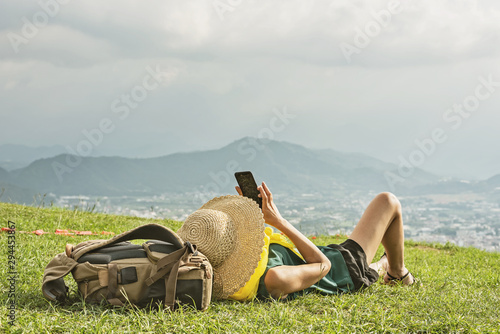 woman lie on grassland and take a picture