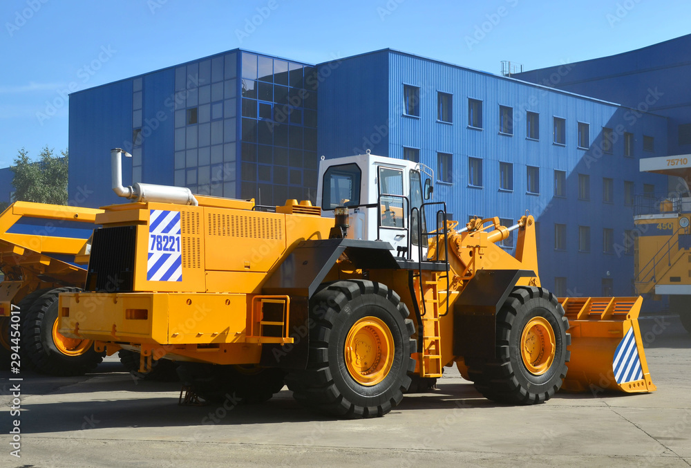 Large front-end loader or all-wheel bulldozer manufacture by the heavy vehicle plant. New heavy quarry equipment with bucket for sales. Coal mining, granite, gravel, sand.