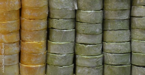  yellow and green pieces of soap lined with a wall. background of texture