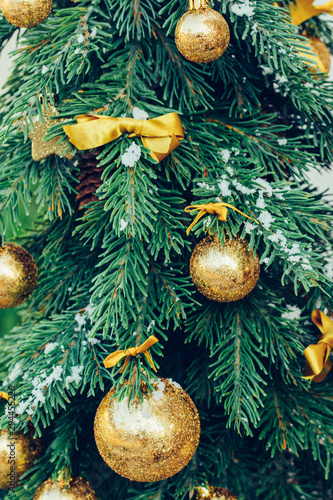 Green fir tree with golden balls. Christmas wallpaper.