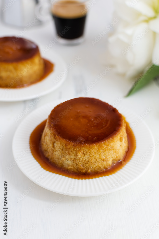 Caramel flan, crema catalana dessert on white woden table Caramel flan, crema catalana dessert on white woden table