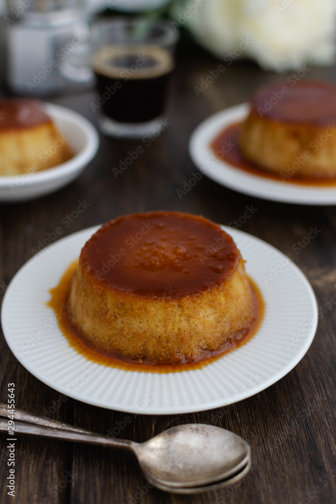 Caramel flan, crema catalana dessert on dark brown woden table Caramel flan, crema catalana dessert on dark brown woden table
