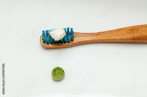 Fotografie wooden toothbrush with the recommended toothpaste size equivalent to the size of