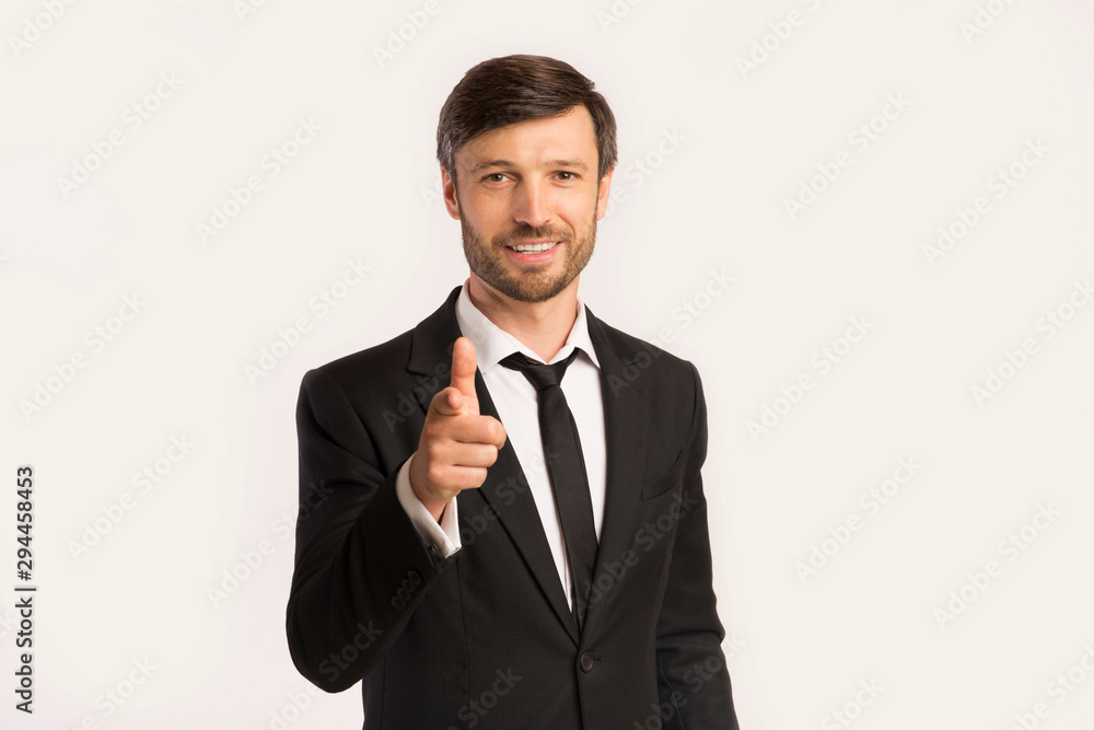 Businessman Pointing Finger At Camera Standing On White Background Businessman Pointing Finger At Camera Standing On White Background