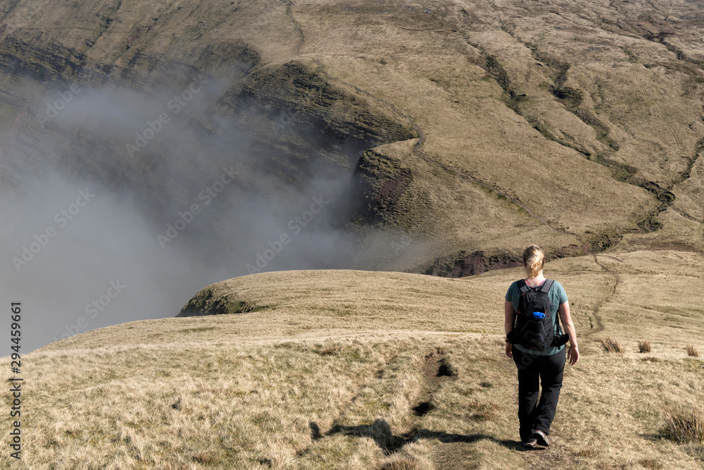 UK, Wales, Brecon Beacons, Young woman hiking at Bannau Sir Gaer Ridge UK, Wales, Brecon Beacons, Young woman hiking at Bannau Sir Gaer Ridge