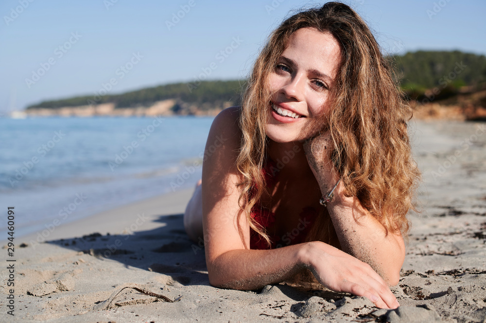 Portrait of happy young woman lying on the beach Portrait of happy young woman lying on the beach