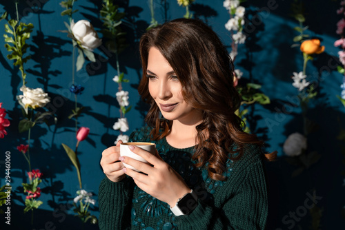Portrait of a beautiful brown-haired girl in a cafe with a cup of tea
