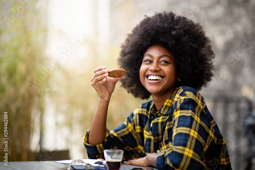 happy young black woman eating cookie
